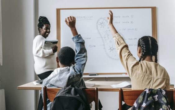 Black woman with pupils in classroom