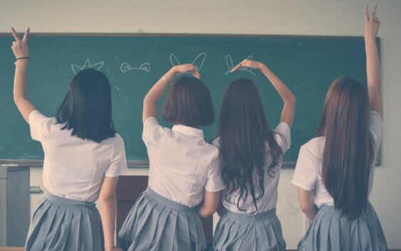 Photo of Four Girls Wearing School Uniform Doing Hand Signs